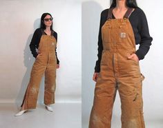 "Vintage '80s faded camel overalls. Made of a heavier canvas type cotton. Faded & worn with stains. Adjustable suspender straps with brass hardware. Brass zipper fly. Front, chest, + back pockets. Carhartt label on front chest pocket. Straight legs with zippers at sides. Pants have a padded, quilted lining. Great fading & hige. DETAILS-----> Label: Carhartt Era: '80s Fabric: cotton (acetate lining?) MEASUREMENTS-----> Tag size: n/a - no size marked - should suit sizes medium - larg Vintage Brown Cotton Overalls, Flared Overalls, Floral Palazzo Pants, Carhartt Overalls, Overalls Vintage, Womens Jumpsuits, Wrap Around Skirt, 70s Dress, Denim Jumpsuit