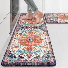 a woman standing on top of a rug in the middle of a kitchen next to an oven