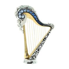 a silver and gold harp with blue crystals on it's sides, sitting in front of a white background