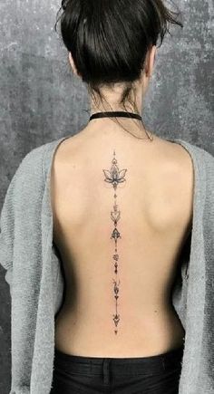 the back of a woman's neck with a cross tattoo on her left side