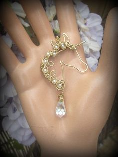 a close up of a person's hand wearing a bracelet with pearls on it