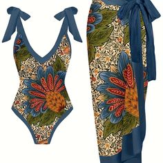 a women's one piece swimsuit with an intricate floral design and blue bow tie