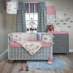 a baby's room is decorated in pink, gray and white with an anchor theme