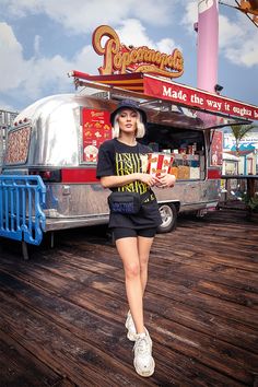 a woman standing in front of a food truck