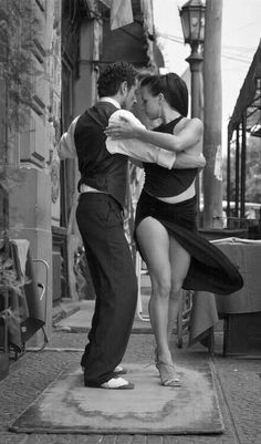 a man and woman are dancing on the street