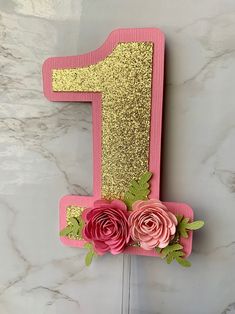 a pink and gold number one decorated with flowers