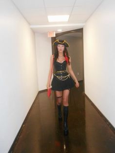 a woman in a pirate costume walking down a hallway