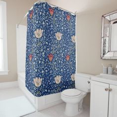 a bathroom with a blue shower curtain next to a white toilet and sink in it