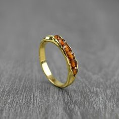 a gold ring with an orange stone in the middle