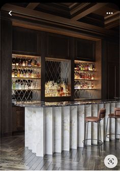 a bar with stools and bottles on the back wall, along with marble counter tops