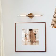 a framed photograph hanging on the wall next to a light fixture and lampshade