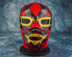 a red and yellow mask on a black base