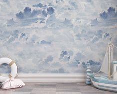 a room with blue and white clouds painted on the wall next to a life preserver