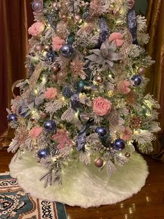 a white christmas tree with pink and blue ornaments