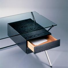 a glass desk with a drawer on it and a pen in the bottom drawer next to it