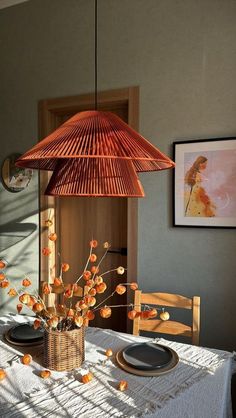 a dining room table with a basket on top of it and flowers in the center