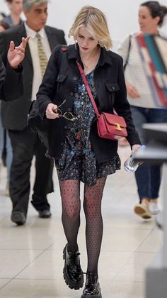 a woman in tights and heels walking through an airport