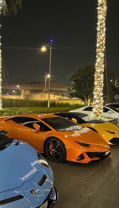 several different colored sports cars parked next to each other in a parking lot at night