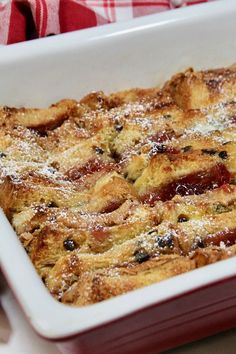 a casserole dish with fruit and powdered sugar in it on a table