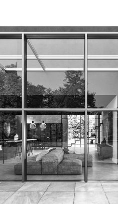 a black and white photo of a living room with large glass doors to the outside