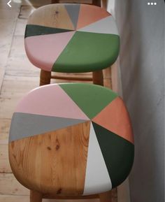 two wooden chairs with different colored designs on them