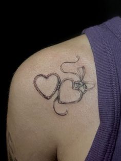 a woman with a tattoo on her shoulder that reads 50 and has two hearts in the middle