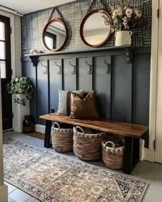 a bench with two mirrors above it and some baskets on the floor next to it