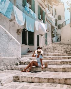 a woman sitting on some steps talking on her cell phone