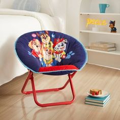 a child's chair with paw patrol on it in a bedroom next to a book shelf