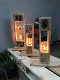 three mason jar lanterns sitting on top of a wooden table