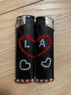 two black lighters decorated with red and silver beads