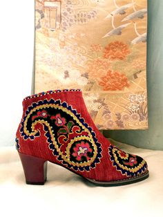 Short Silk Petit Point Boots from Uzbekistan with leather lining. These boots are created from hand drawn designs on cotton canvas, inspired by original designs from ancient Uzbekistan textile history. Height measures 6" with a 2.5" heel. Size 37 (US 7) available. 100% silk petit point with leather lining with leather sole. Zip closure. Handmade in Uzbekistan. Your purchase preserves and encourages Folk Art Traditions in Uzbekistan, enabling women, families and communities to preserve their traditions and contributes to the health and well being of the communities at large. Your purchases helps a long chain of women working hard to preserve our dignity and integrity to live in a world that recognizes creativity in it's many forms and rewards it with your support.  Thank you for your suppor Textile History, Pointed Boots, Womens Booties, Booties Ankle Boots, Embroidered Shorts, Boho Festival, Hand Drawn Design, Long Chain, Boot Shoes Women