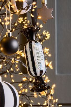 an ornament hanging from the side of a christmas tree with lights on it