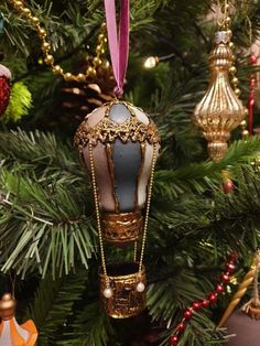 an ornament is hanging from a christmas tree in the shape of a hot air balloon