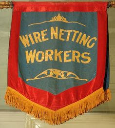 a red and blue sign that says wire netting workers hanging from the ceiling in front of a door