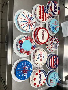 cupcakes decorated with red, white and blue frosting are arranged on a refrigerator door