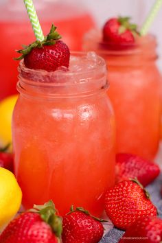 two mason jars filled with lemonade and strawberries