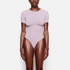 Cotton Jersey T-shirt Bodysuit | Iris Mica — A fitted crewneck bodysuit that gives a tucked-in tee look, perfect for everyday wear. Stretchy, breathable jersey fabric hugs your curves, making it perfect for wearing as a base layer or alone. Casual Second-skin Bodysuit With Scoop Neck, Trendy Stretch Short Sleeve Bodysuit, Trendy Fitted Short Sleeve Bodysuit, Trendy Stretch Crew Neck Short Sleeve Bodysuit, Casual Second-skin Seamless Bodysuit, Trendy Crew Neck Short Sleeve Bodysuit, Trendy Stretch Short Sleeve Bodysuit With Scoop Neck, Basic Stretch Short Sleeve Bodysuit With Crew Neck, Basic Short Sleeve Stretch Bodysuit With Crew Neck