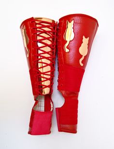 a pair of red boxing gloves with cats on the side and laces around them