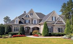 a large house with lots of windows and bushes around it's front yard area