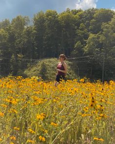 a woman standing in a field full of yellow flowers