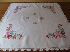 an embroidered tablecloth with flowers on it