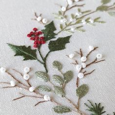 embroidered holly and berries on white fabric