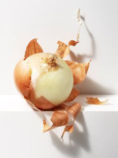 an onion is cut in half on a white surface