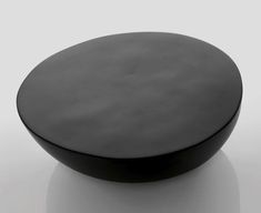 a round black object sitting on top of a white surface