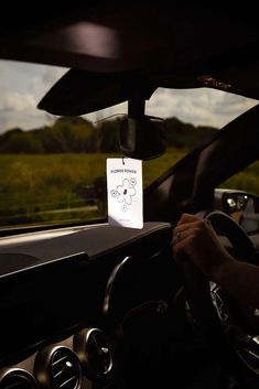 a person driving a car with a sign on the dashboard that says, don't stop