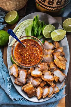 a plate with some food on top of it next to limes and other foods