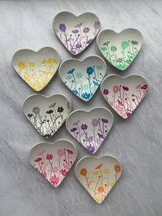 six heart shaped dishes with flowers painted on them