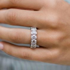 a woman's hand wearing a white gold ring with three baguettes on it