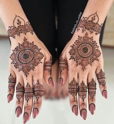 two hands with henna tattoos on them